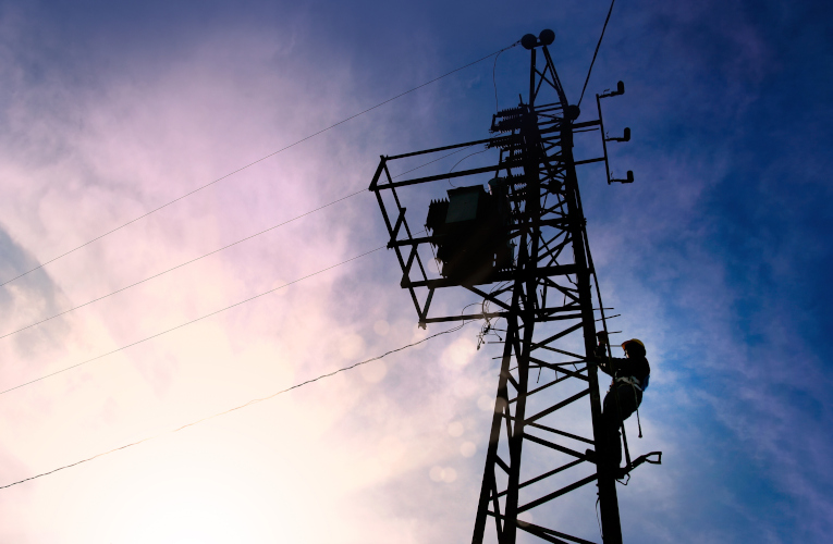 Electrician worker climbing electric power pole 