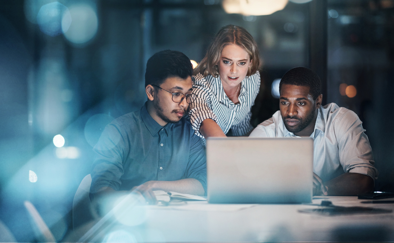 three people in front of laptop